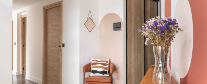 Entrée avec chaise design, arche peinte et mobilier en bois décorée par Julie Porcella, décoratrice d’intérieur à Grenoble et en Isère