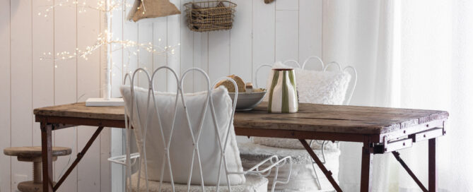 Salle à manger du projet M Vercors avec table en bois brut, chaises en métal blanc, suspension dorée et arbre lumineux décoratif. Projet de décoration intérieure Isère - residentiel.